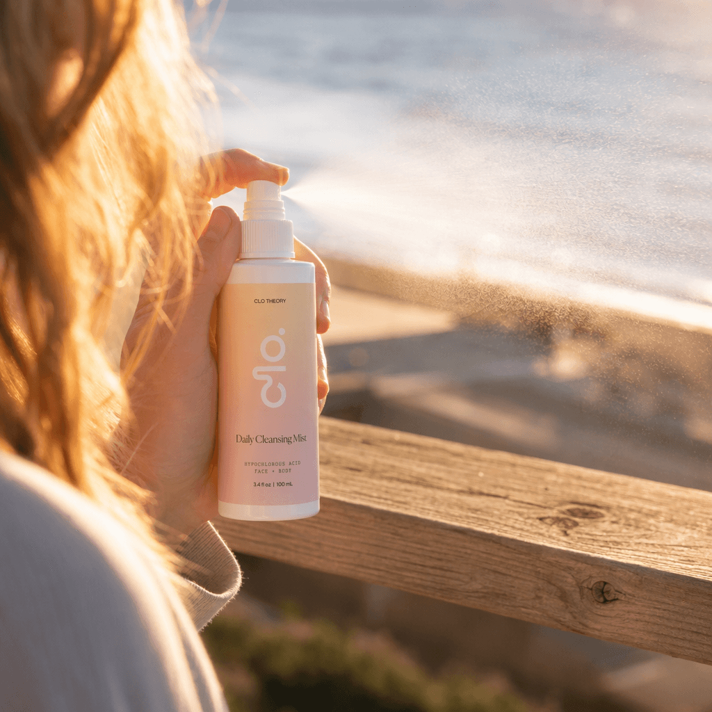 Hand spraying Clo mist at sunset beach