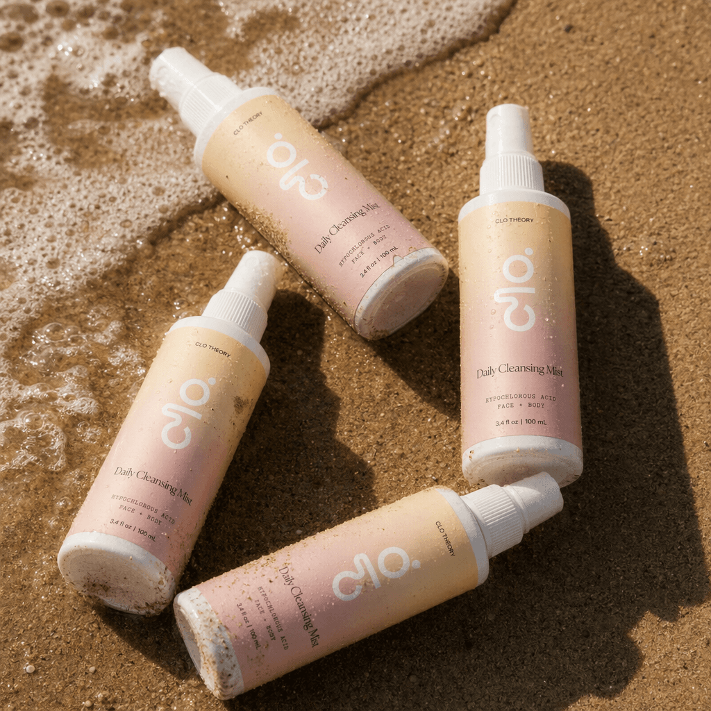 Clo bottles on wet sand, caught where a wave meets the shore